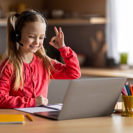 Little Girl Having Video Call On newly donated laptop by Give IT Forward At Home, Showing Ok Gesture